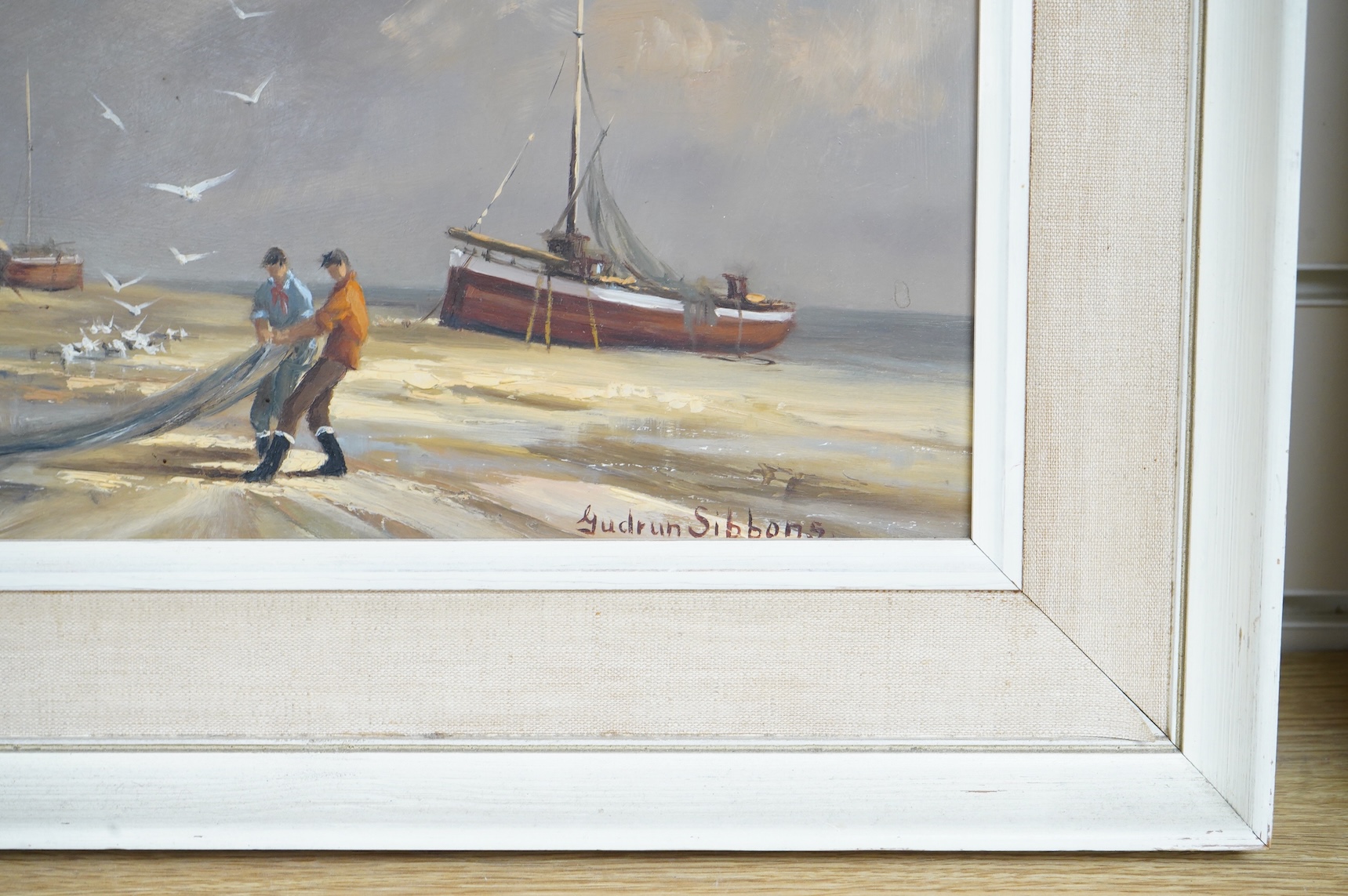 Gudrun Sibbons (1924-2020), Coastal view with beached fishing boats and fishermen, signed, oil on board, 39 x 49cm